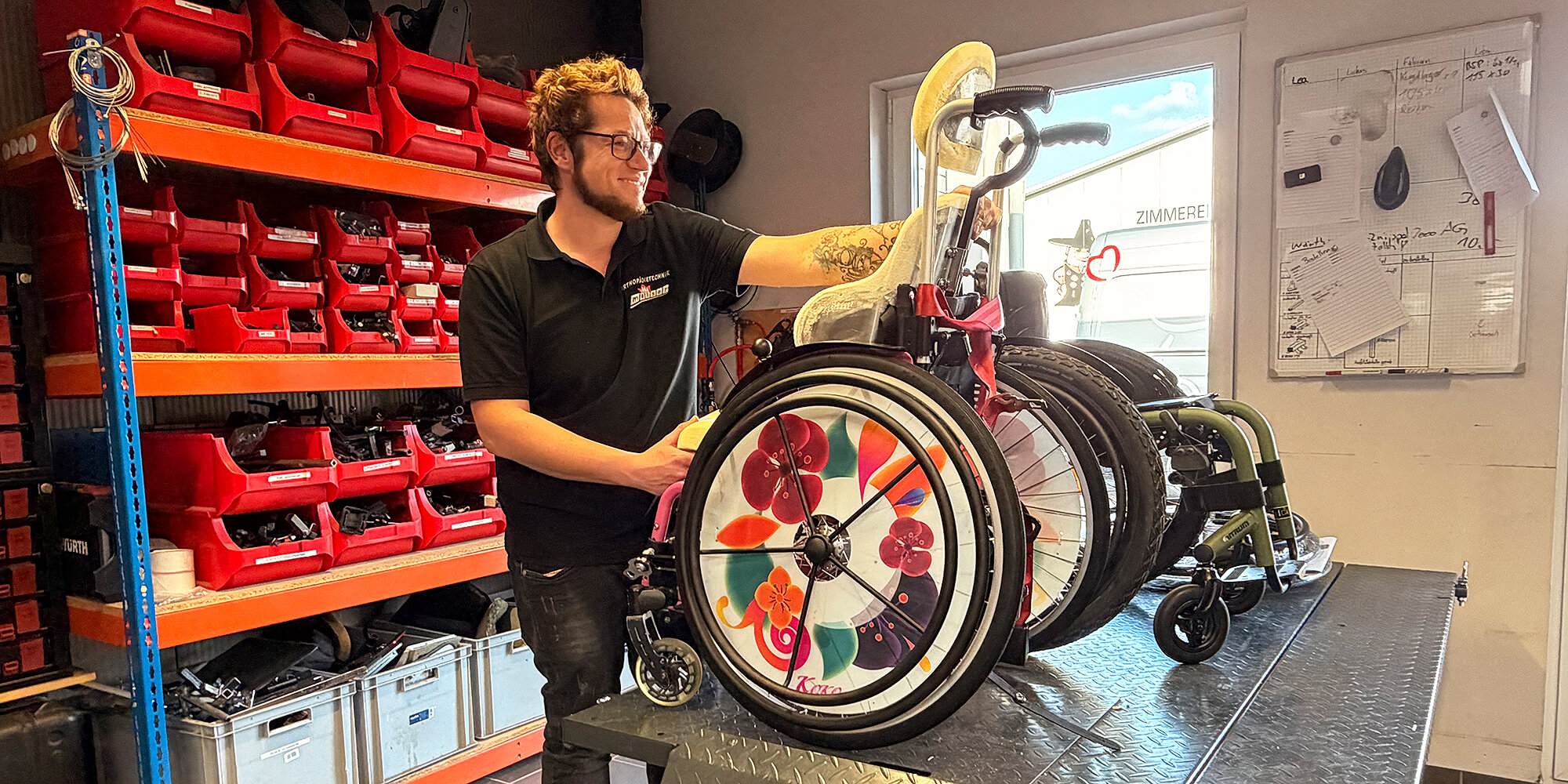 Orthopädietechniker wartet und passt einen individuell angepassten Kinderrollstuhl in der Werkstatt mit Werkzeugen und Ersatzteilen an